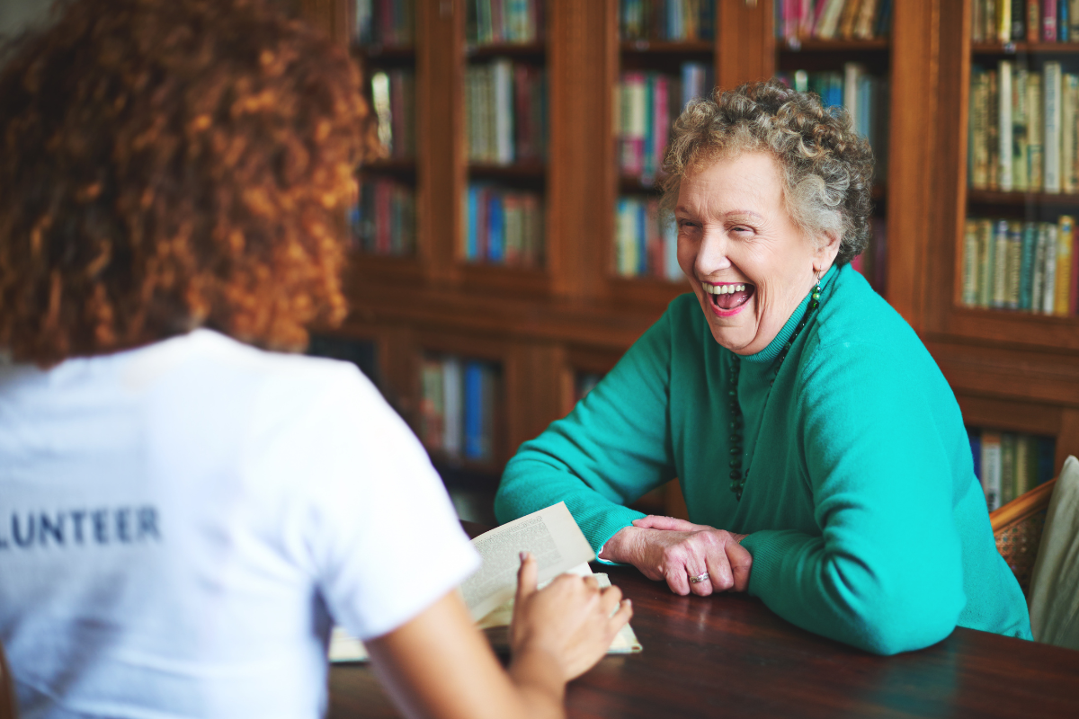 Volunteer recruitment and engagement training session showing a volunteer building positive relationships and supporting a community member through one-to-one conversation.